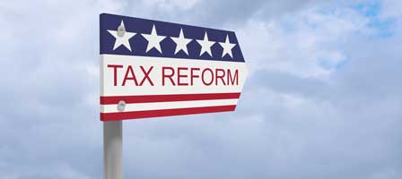 Sign in shape of arrow with Tax Reform written on it. The sign features blue stars and red stripes like a flag.